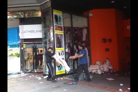 Local shopkeepers tidy their looted store